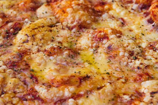 Close-up of pizza topped with cheese and oregano. Macro shot of delicious products. Selective focus.