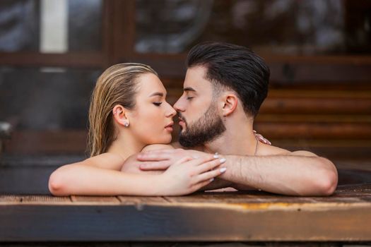 portrait of a couple kissing in a tub of water