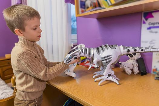 little boy playing with robots while sitting on self-isolation