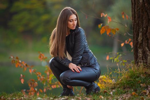 girl in black leather clothes near the tree