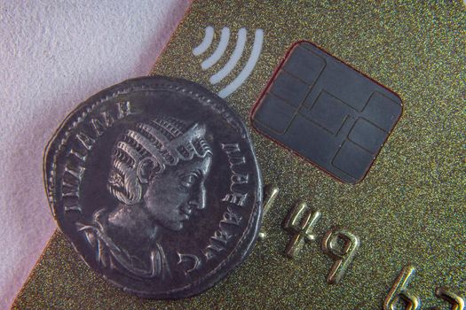 Old coin near NFC chip close up