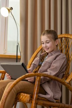 portrait of a girl with a tablet sitting in a chair