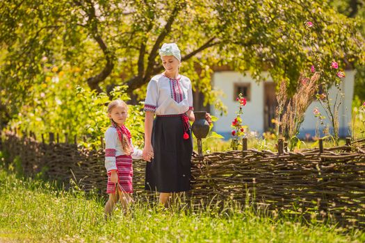 mother and daughter in Ukrainian national costumes are walking on the street