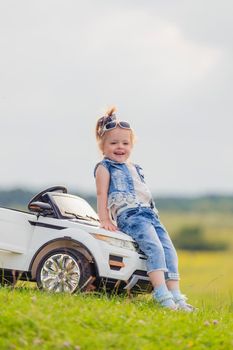 girl in sunglasses stands near the car in nature