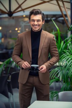 a man in a business suit is drinking tea