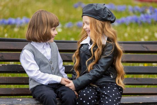 children sit on a bench in the city and talk