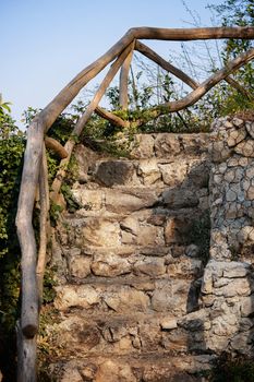 Old stone stairs overgrown by plants. Close up of ancient stone stairway steps.