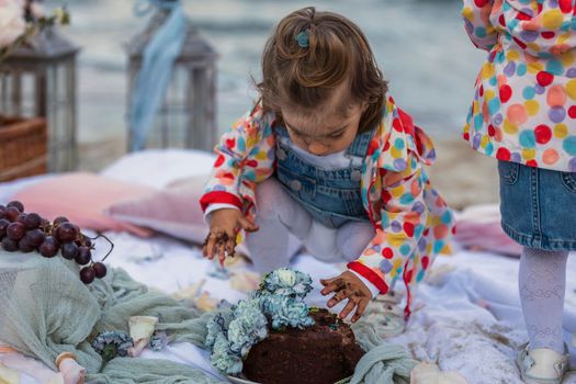 children eat chocolate covered cake with their hands