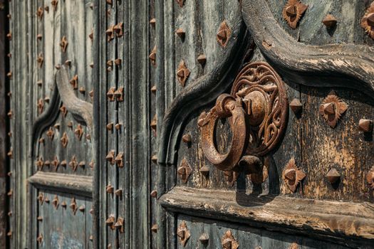 Details of portal to Cathedral. Metal knocker on wrought iron reinforced old wooden doors to Girona Cathedral, Spain.