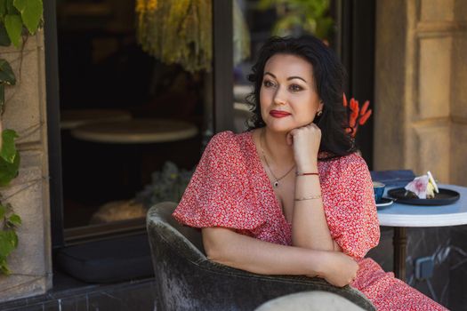 Woman in red dress and sitting on a high chair