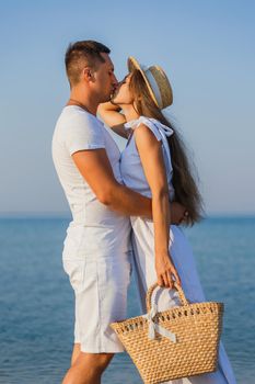 couple in white clothes kissing on the background of the sea