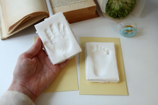 Baby handprint on womans and footprint with copy space. New life concept. parents memories.