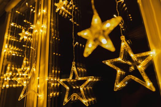 christmas glowing garland in the form of stars on the window