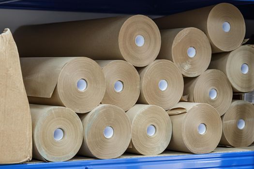 Craft paper rolls folded on a shelf in a warehouse.