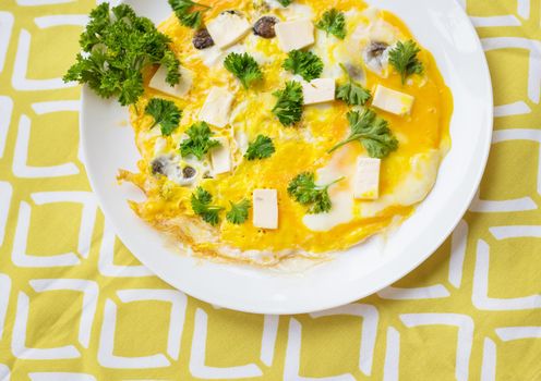 Scrambled eggs with fresh herbs on a plate.