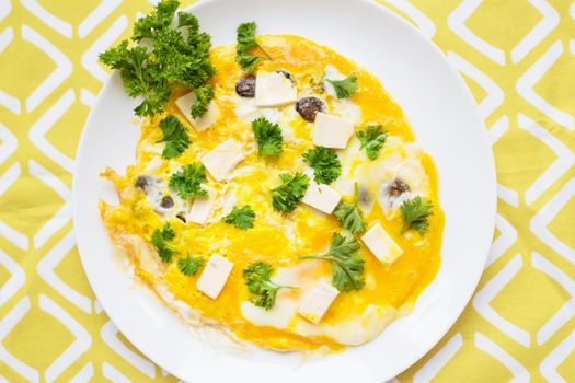 Scrambled eggs with fresh herbs on a plate.