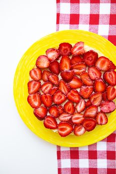 Bright and delicious strawberry cake on a red napkin in a cage.