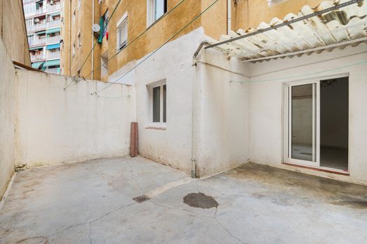 Empty and old patio of typical apartment in Barcelona, Spain. Worn out courtyard on lowest floor.