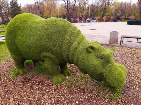 Decorative sculpture of a hippopotamus in a city park close-up.