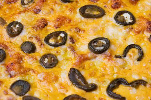 Close-up of pizza topped with olives and cheese.. Macro shot of delicious products. Selective focus.