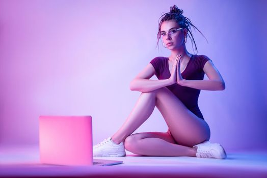 a girl with a laptop in neon light