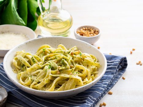 Tagliatelle pasta with pesto sauce made of Basil, garlic, pine nuts, olive oil. Side view.