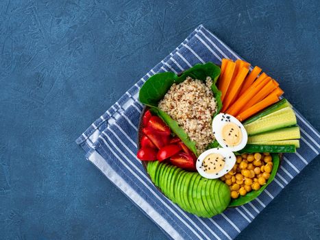Vegetarian Buddha's bowl, a mix of vegetables. Avocado, quinoa, chickpeas, vegetables, eggs, top view, copy space.