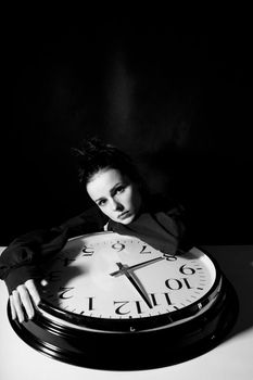 sad woman with big clock, black background. High quality photo