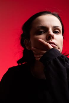 brunette woman in black clothes on red background. High quality photo