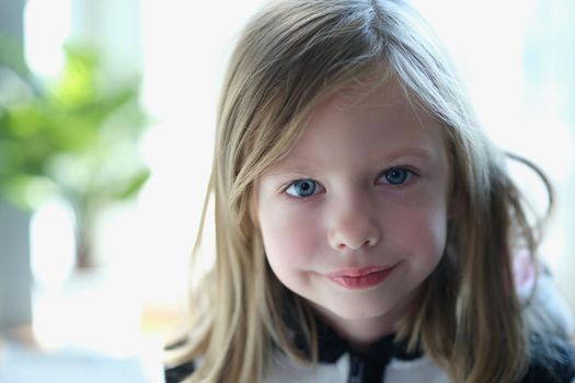 Portrait of little smiling child posing and looking at camera with happiness. Cheerful girl kid. Happy childhood concept