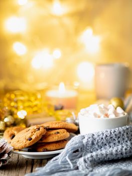 Christmas background with cocoa, marshmallow. Cozy evening, cup of drink, Christmas decorations, candles and lights garlands