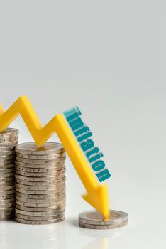 Decrease in inflation. The recession of the economy and the euro. The concept of economic collapse and stock market collapse in the euro area. Stacks of coins and a graph arrow pointing down