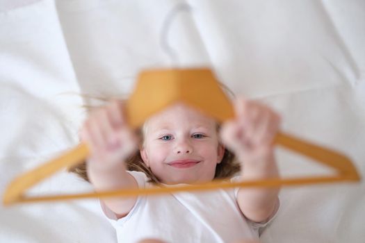 Portrait of little kid having fun in bed at home. Small child resting after active boy. Happy childhood concept