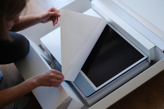 Close-up of woman hands unpacking box with modern personal computer. Latest technological innovations, digital equipment and electronics