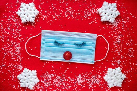 Medical mask with Christmas decoration on a red background