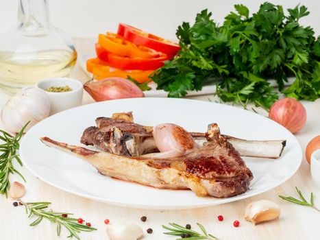 fat fried lamb ribs on white plate with vegetable and seasoning on white marble table, ketogenic, paleo, lchf fat diet fat, side view