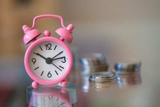Close-up of alarm clock and money coin stack on table. Finance sustainable development, economic growth. Banking and business idea. Time for savings money concept