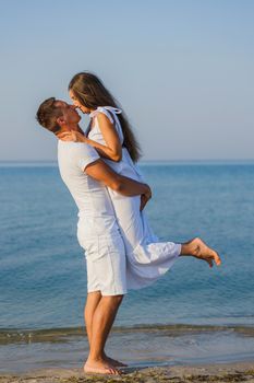 couple in white clothes kissing on the background of the sea