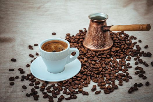 Coffee turk and cup of coffee on burlap background. coffee beans isolated on white background. roasted coffee beans