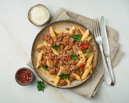 Bolognese pasta. Fusilli with tomato sauce, ground minced beef. Traditional italian cuisine. Marble table. Top view.