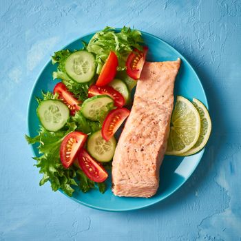 Steam salmon and vegetables, Paleo, keto, fodmap diet. Blue plate on blue table, top view