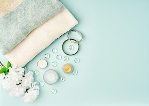 Flat lay woman accessories with cosmetic, facial cream on pastel blue table, copy space.