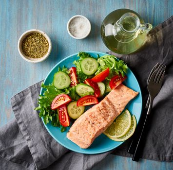 Steam salmon and vegetables, Paleo, keto, fodmap diet. Blue plate on blue table, top view