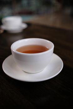 white cup of tasty tea blurred background