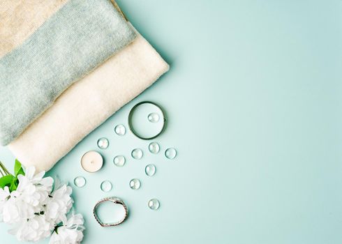 Flat lay woman accessories with sweater on pastel blue table, copy space.