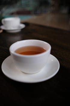 white cup of tasty tea blurred background