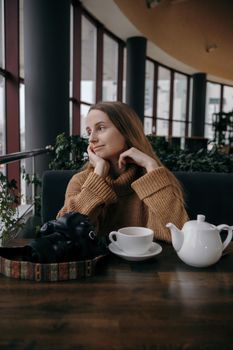 Attractive girl with a cup of coffee in the cafe