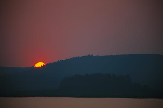Sunset in the bay against mountainous background.