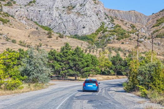 Car Moves along a winding road in the mountains during the day