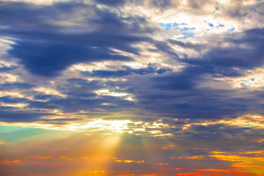 sunset rays of the sun make their way through the dense veil of clouds